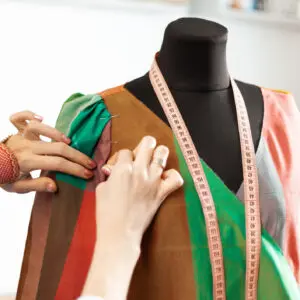 Fashion designer pinning fabric on dress form