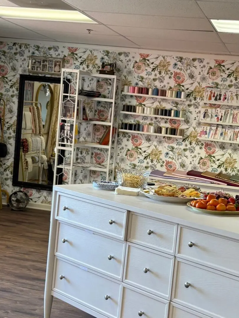 Cozy kitchen with floral wallpaper and white cabinetry.